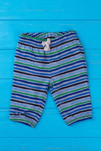 Striped breeches for boy. Blue wood background. - Photo, Image