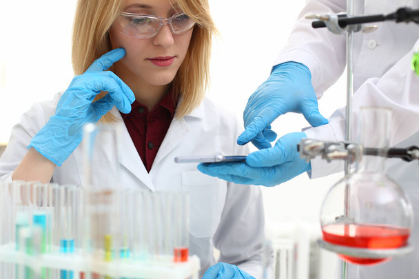 Een vrouwelijke arts in een chemisch laboratorium houdt - Foto, afbeelding