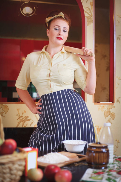 Una donna carina in cucina. Nelle mani che tengono strumenti per cucinare il cibo
. - Foto, immagini