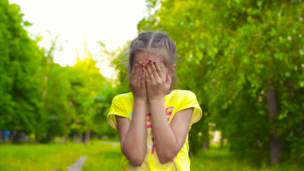 Mädchen spielt und versteckt sich hinter Händen - Filmmaterial, Video