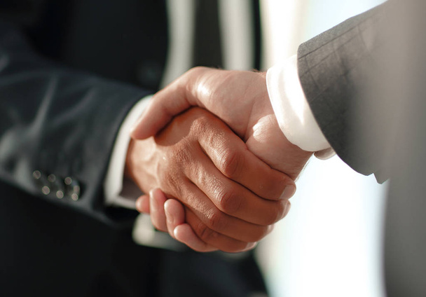 Friendly smiling businessmen handshaking. Business concept photo - Foto, immagini