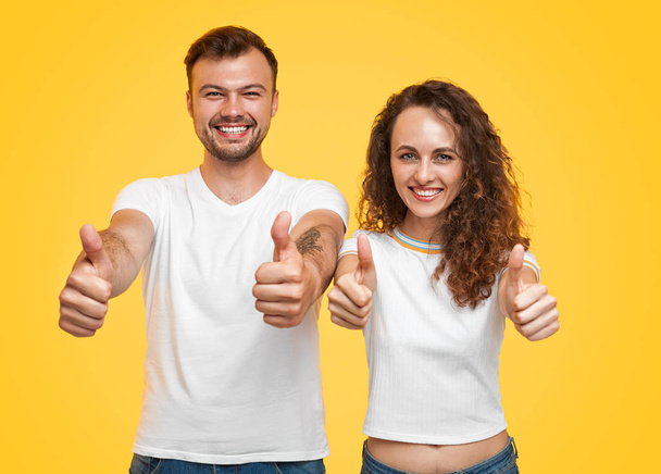 Smiling couple gesturing thumb-up - Foto, imagen