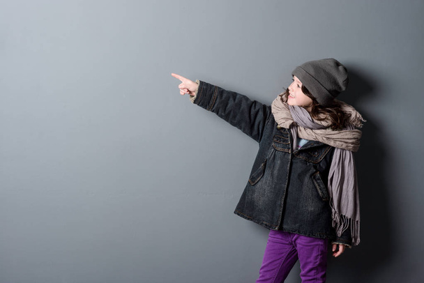 Girl pointing on grey background - Фото, зображення