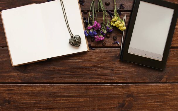 Felülnézet íróasztal sötét fa asztal ebook, szemes kávé, virágok, notebook és a szív medál. Másolja a hely - Fotó, kép