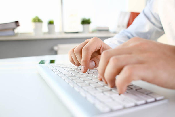 Male arms in suit typing on silver keyboard - Photo, Image