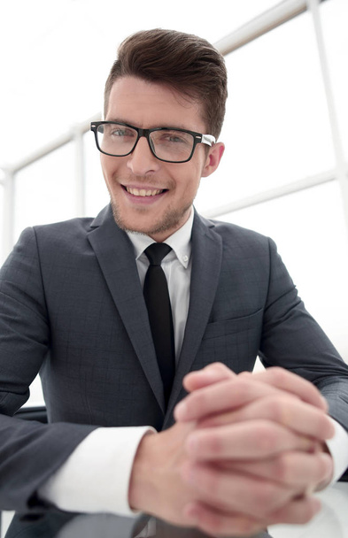 close up.smiling businessman sitting at his Desk - Фото, изображение