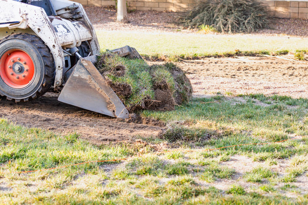Piccolo bulldozer che rimuove l'erba dal cortile che si prepara per l'installazione della piscina - Foto, immagini
