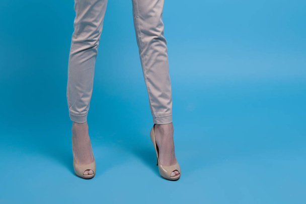 Legs of beautiful successful young businesswoman over blue background. Business and success - Foto, afbeelding