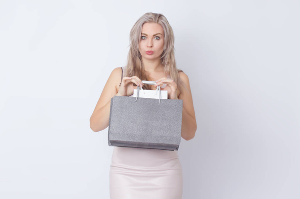 Closup studio portrait of stylish blonde woman over white background. Concept: Shopping. Woman with bags in borth hands - Foto, Imagem