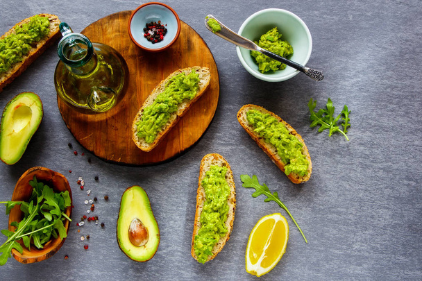 Avocado toasts and ingredients flat lay. Good fats raw healthy eating concept. - Фото, зображення