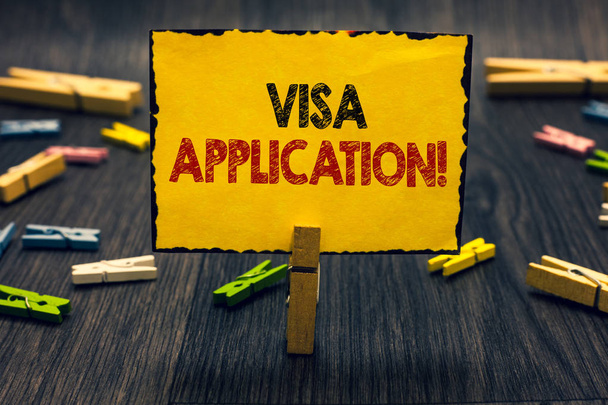 Word writing text Visa Application. Business concept for Form to ask permission travel or live in another country Blacky wooden desk laid paper clip randomly one hold yellow board with text. - Photo, Image