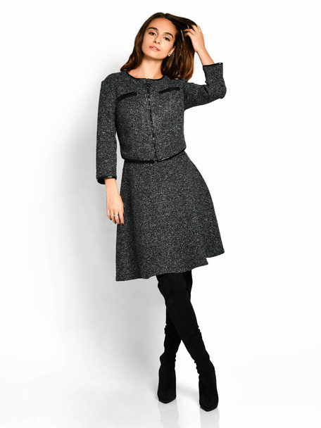 Young beautiful woman posing in new gray fashion winter dress on high boots full body - 写真・画像