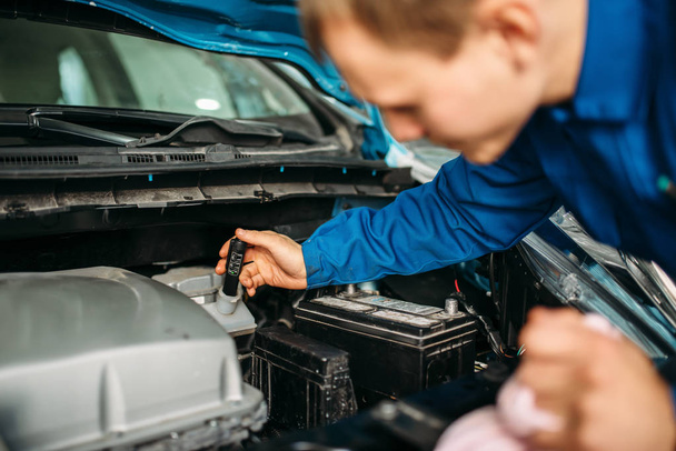 Il tecnico maschio controlla il livello del liquido dei freni in auto. Auto-service, manutenzione del veicolo, riparatore con utensili
 - Foto, immagini