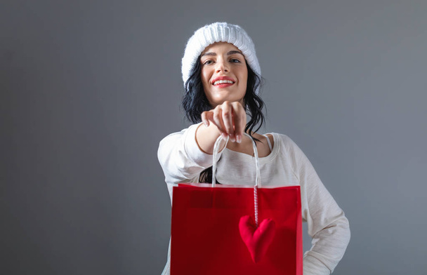 Happy young woman holding a shopping bag - Fotó, kép