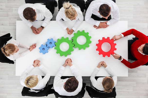 Business problem solution, mechanism of business, teamwork concept, business team sitting around white table with cogs - Foto, Imagem