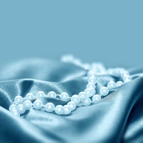 Perlen auf einem seidenen Stoff Hintergrund - Foto, Bild
