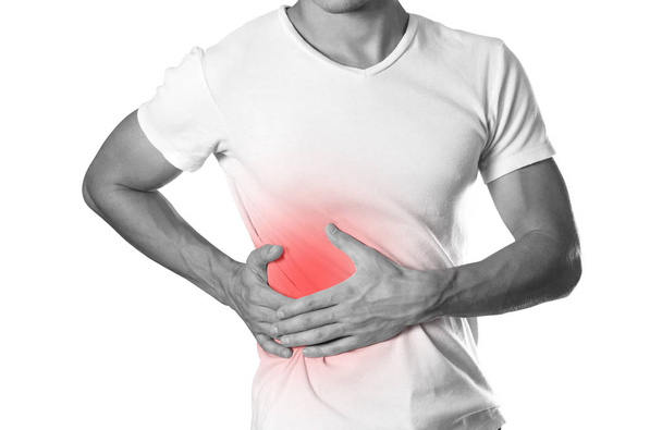 The man is holding his side. Pain in the liver. Cirrhosis. The hearth is highlighted in red. Close up. Isolated on white background. - Photo, Image