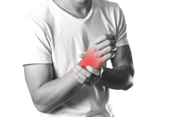 A man holding hands. Pain in the wrist. The hearth is highlighted in red. Close up. Isolated on white background. - Photo, Image