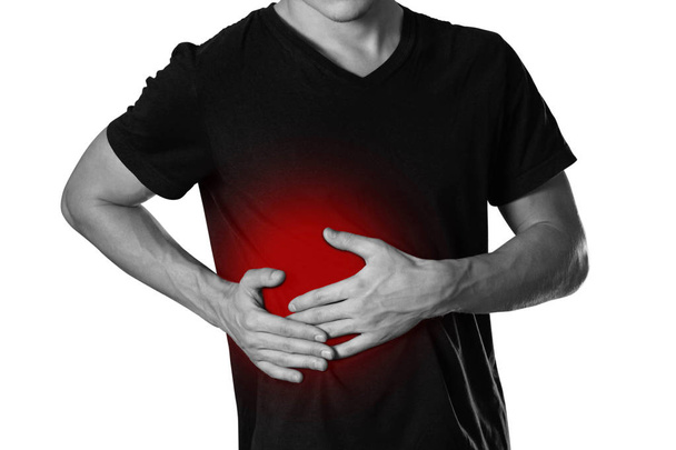 The man is holding his side. Pain in the liver. Cirrhosis. The hearth is highlighted in red. Close up. Isolated on white background. - Photo, Image