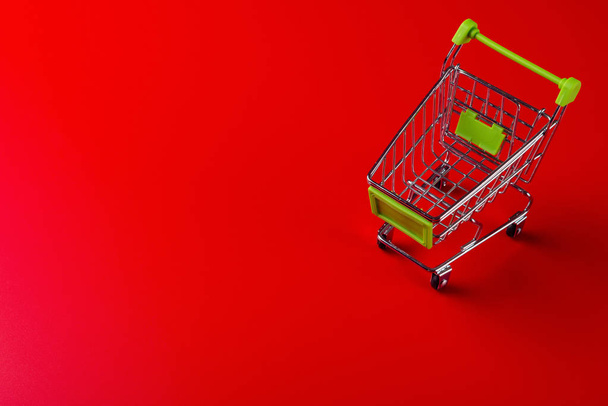 empty shopping cart on red background - Zdjęcie, obraz