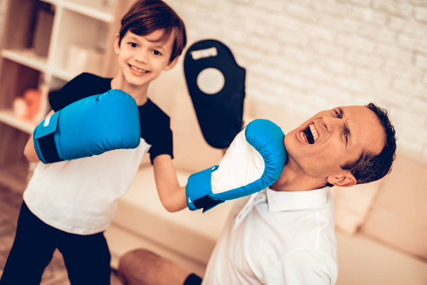 Boy Standing. Father and Son Boxer. Sport at Home. Warm Up in Quarter. Boxing Supplies in Hands. Boxing Gloves. Doing Sports. Man and Boy Train at Home. Child in Boxing Gloves in Apartment. Little Boy - Foto, immagini