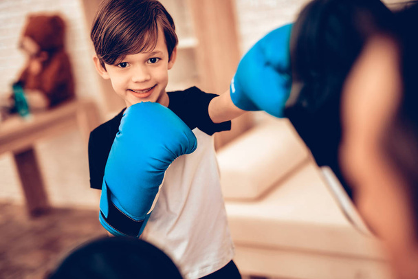 Boy Boxer. Father and Son Boxing. Sport at Home. Warm Up in Quarter. Boxing Supplies in Hands. Boxing Gloves. Doing Sports. Man and Boy Train. Child in Boxing Gloves in Apartment. Little Boy. - Foto, imagen