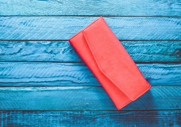 Trendy rode tas op een blauwe achtergrond van houten. Bovenaanzicht. Trend van minimalisme. - Foto, afbeelding
