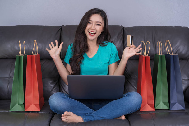 веселая женщина, использующая цифровой планшет для онлайн-покупок с кредитной картой в гостиной
 - Фото, изображение