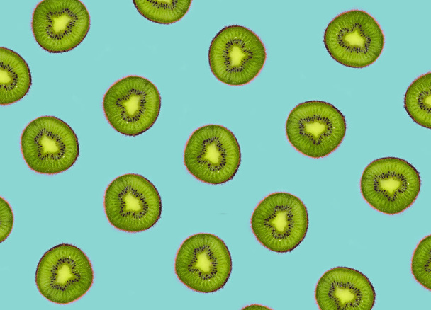 Creative background of kiwi slices on a purple surface. Top view. - Фото, зображення