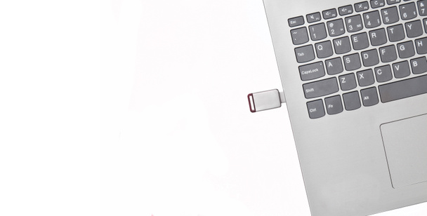 USB flash drive inserted into a laptop isolated on a white background. Modern digital media. - Photo, Image