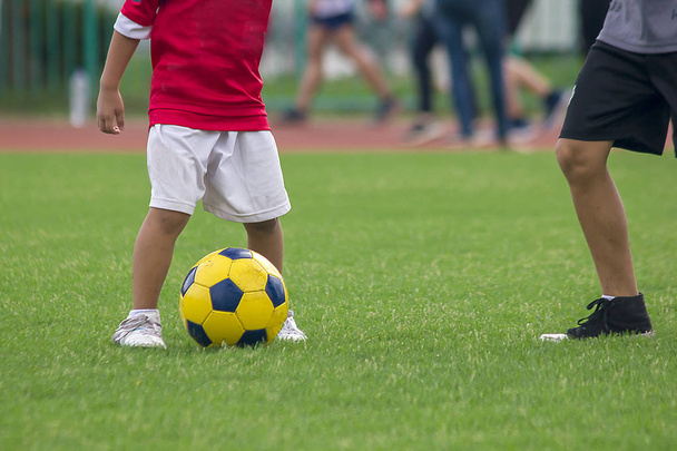 Ноги дітей штовхають футбол
. - Фото, зображення
