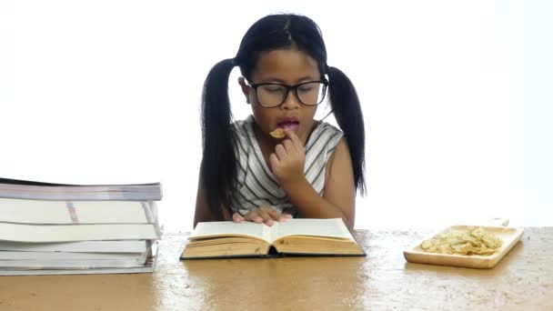 Meisje het lezen van een boek en Franse frietjes eten op witte achtergrond, - Video