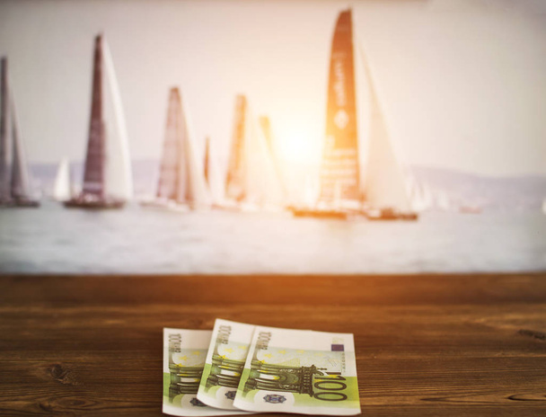 Euro money on the background of a TV on which show sailing, sports betting, yachting, sailing - Фото, изображение