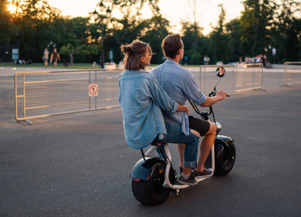 Charmant jeune couple conduisant un vélo électrique pendant l'été
 - Photo, image