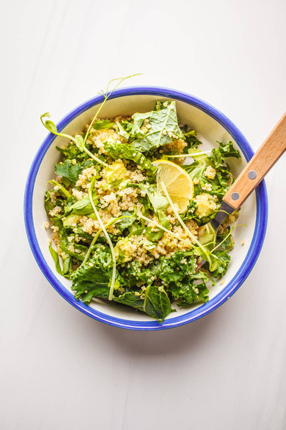 Kale, quinoa, avocado vegan salad in a white bowl on a white background. Plant based diet concept. - Fotografie, Obrázek