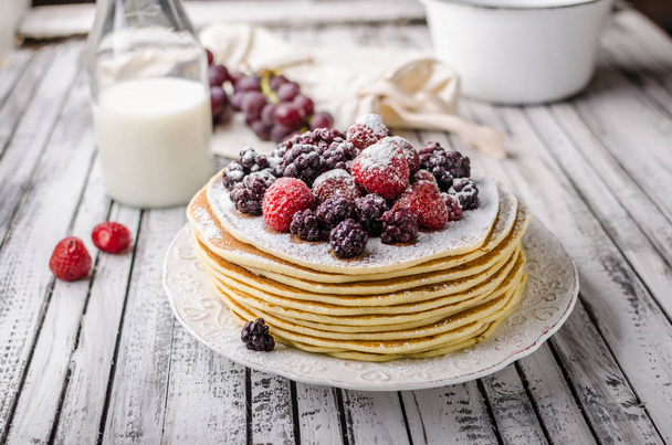 Homemade crepes with frozen berries, topped sugar, rustic wood board, vintage photography - Fotografie, Obrázek