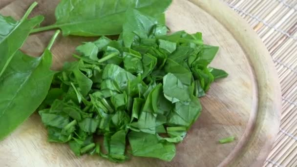 Rotating fresh cut healthy food spinach on wooden cutting board - Footage, Video