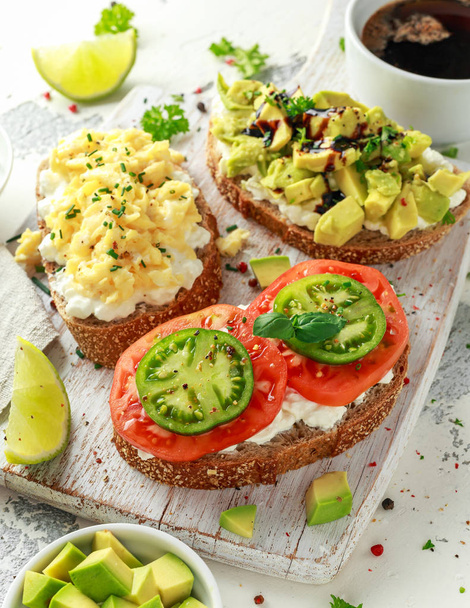 Vegetariano Pane tostato sano con ricotta, pomodori cimelio, uova strapazzate e avocado
 - Foto, immagini