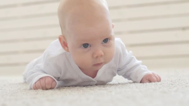Felice bambino sdraiato su sfondo tappeto, sorridente neonato ragazza in abbigliamento bianco
 - Filmati, video