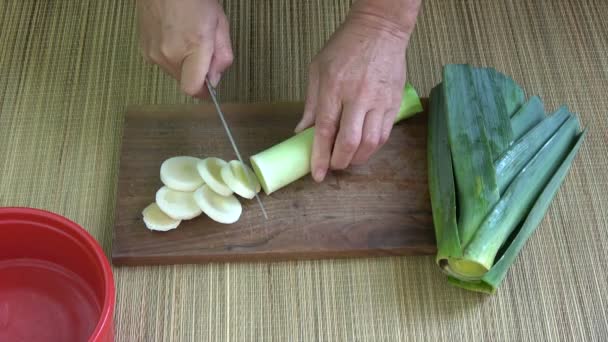 Tagliare porro vegetale fresco sul tagliere in cucina
 - Filmati, video