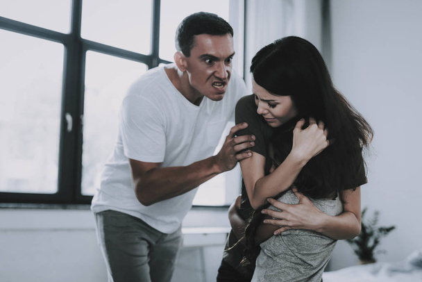 Angry Man Grabbed Frightened Wife and Daughter. Father Wears Casual Clothes Screams Aims Blow at Woman and Child in Room. Family Conflict and Relationship Problems Concept - Photo, Image