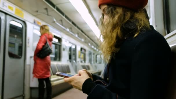 Γυναίκα χρησιμοποιεί ένα smartphone στο μετρό, το κορίτσι χρησιμοποιεί το τηλέφωνο στο αυτοκίνητο - Πλάνα, βίντεο