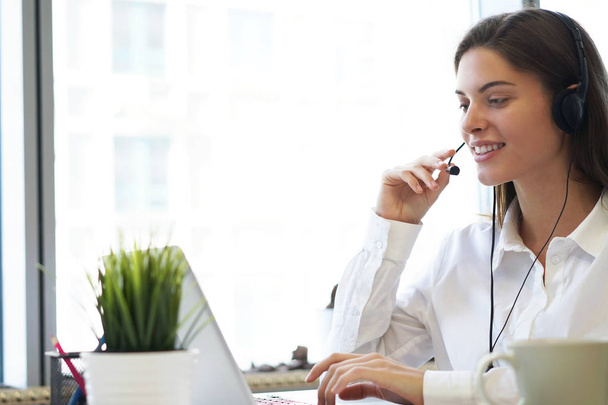 Female customer support operator with headset and smiling. - Φωτογραφία, εικόνα