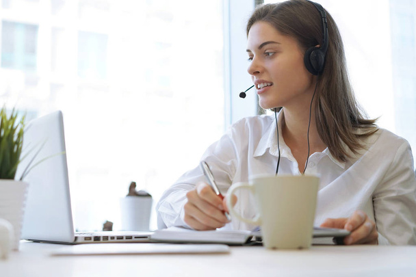 Woman customer support operator with headset and smiling. - Fotó, kép