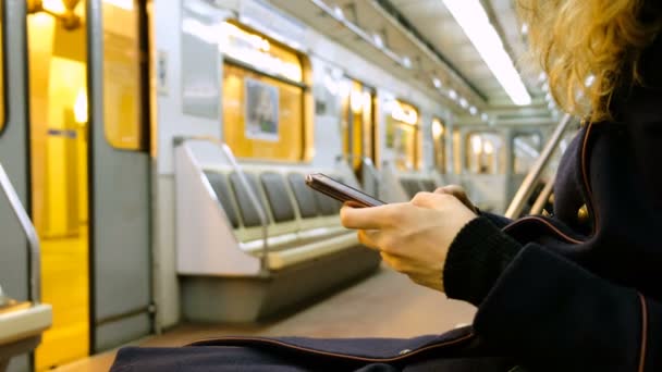 Vrouw maakt gebruik van een smartphone in de metro close-up - Video
