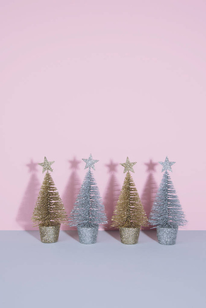 Christmas trees over light pink background. - Valokuva, kuva