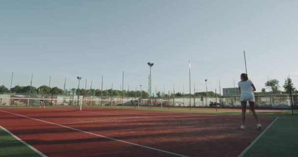 Full game of tennis outside on the tennis court , two sportiv women playing professional. - Felvétel, videó
