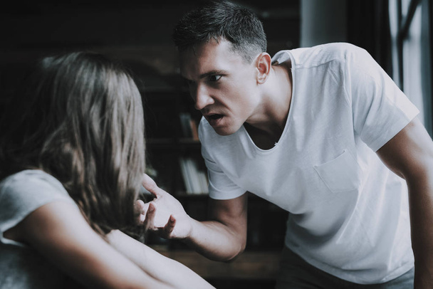 Fight and Quarrel between Father and Girl at Home. Portrait of Relatives Scolding and Arguing Indoors. Angry Man Holds Daughters Hand and Having Conflict in Bedroom. Family Violence Concept - Valokuva, kuva