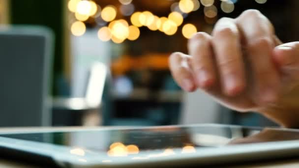 Mujer mano utiliza una PC tableta en un café sobre un fondo borroso primer plano
 - Metraje, vídeo