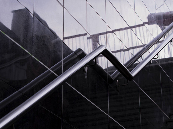 Staircase stainless steel handrails. Modern stairs with Stainless steel railings in a new modern Underpass . Reflection and shadows on the glass wall. Modern design. - Photo, Image